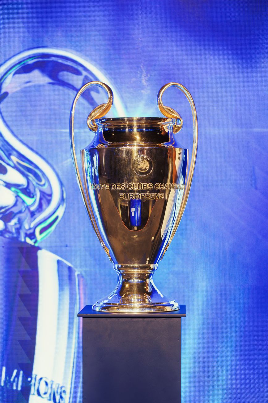 Close-up van de UEFA Champions League-trofee op een voetstuk binnenshuis.