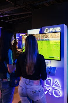 Two women playing FIFA on a PlayStation 5 console in a modern gaming store.