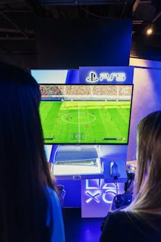 Two gamers playing FIFA on PS5 at a nighttime gaming event.