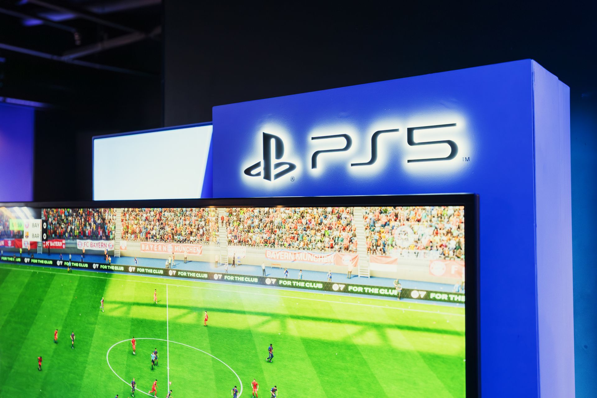 PlayStation 5 display screen at a video game exhibition showing gameplay footage