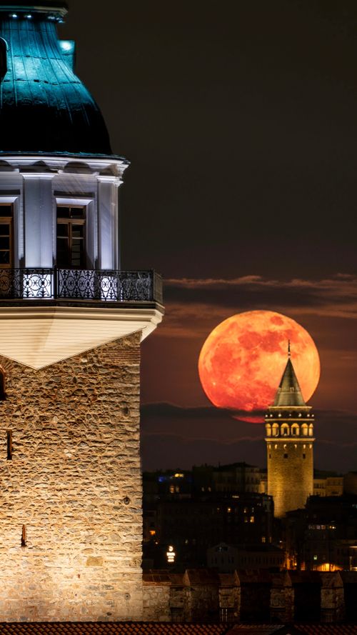 Free The full moon rises majestically behind Istanbul's iconic historical buildings at night. Stock Photo