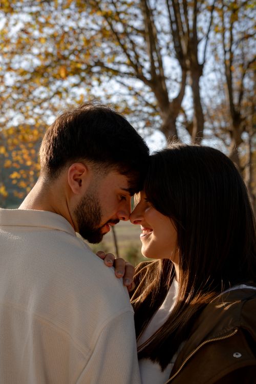 Free Close-up of a couple embracing outdoors in autumn sunlight, Vimeiro, Portugal. Stock Photo