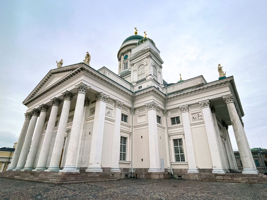 Wide-angle view of Helsinki Cathedral's neoclassical architecture on a cloudy day.