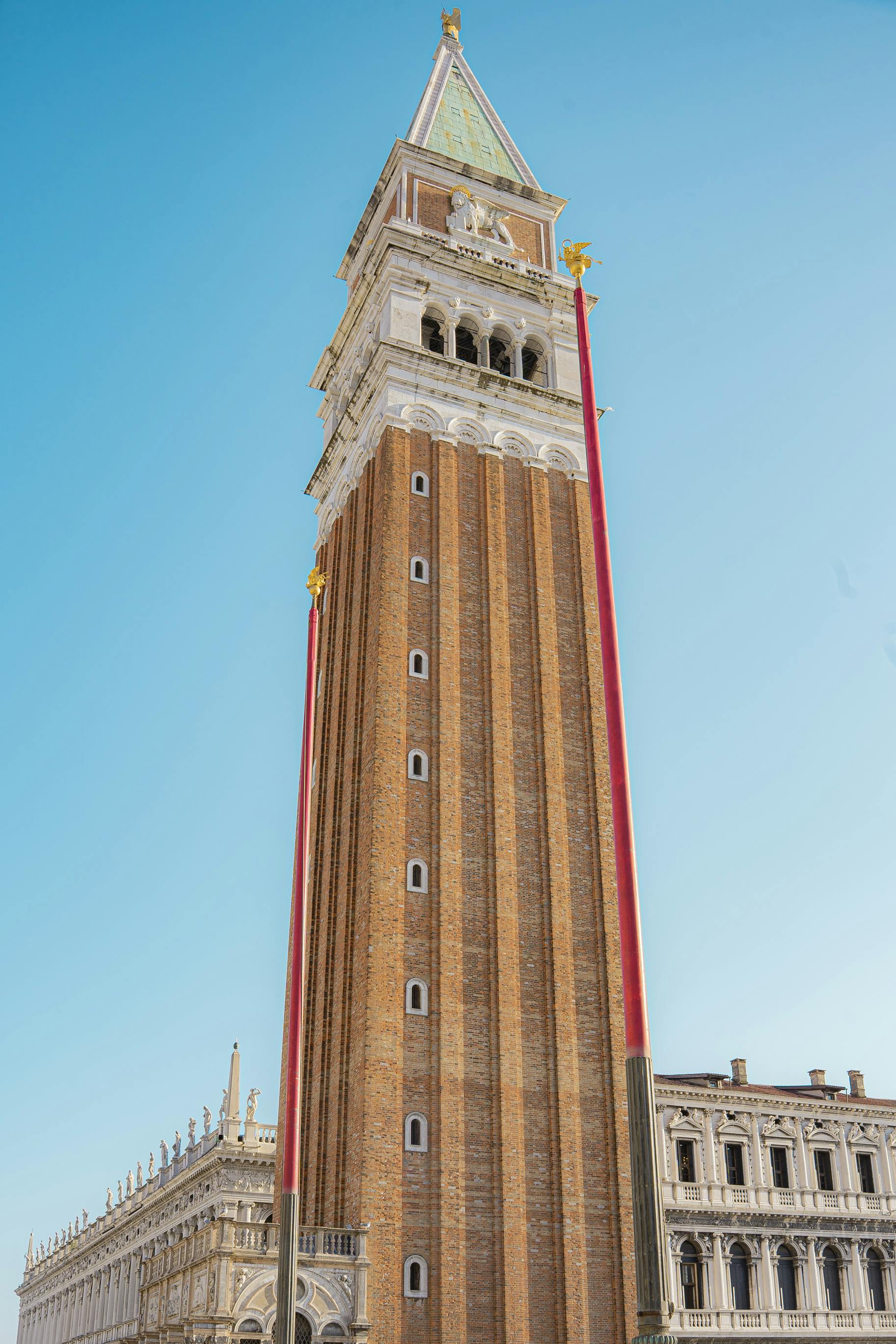 The majestic St Mark's Campanile in Venice against a clear blue sky. A symbol of Italian architecture.