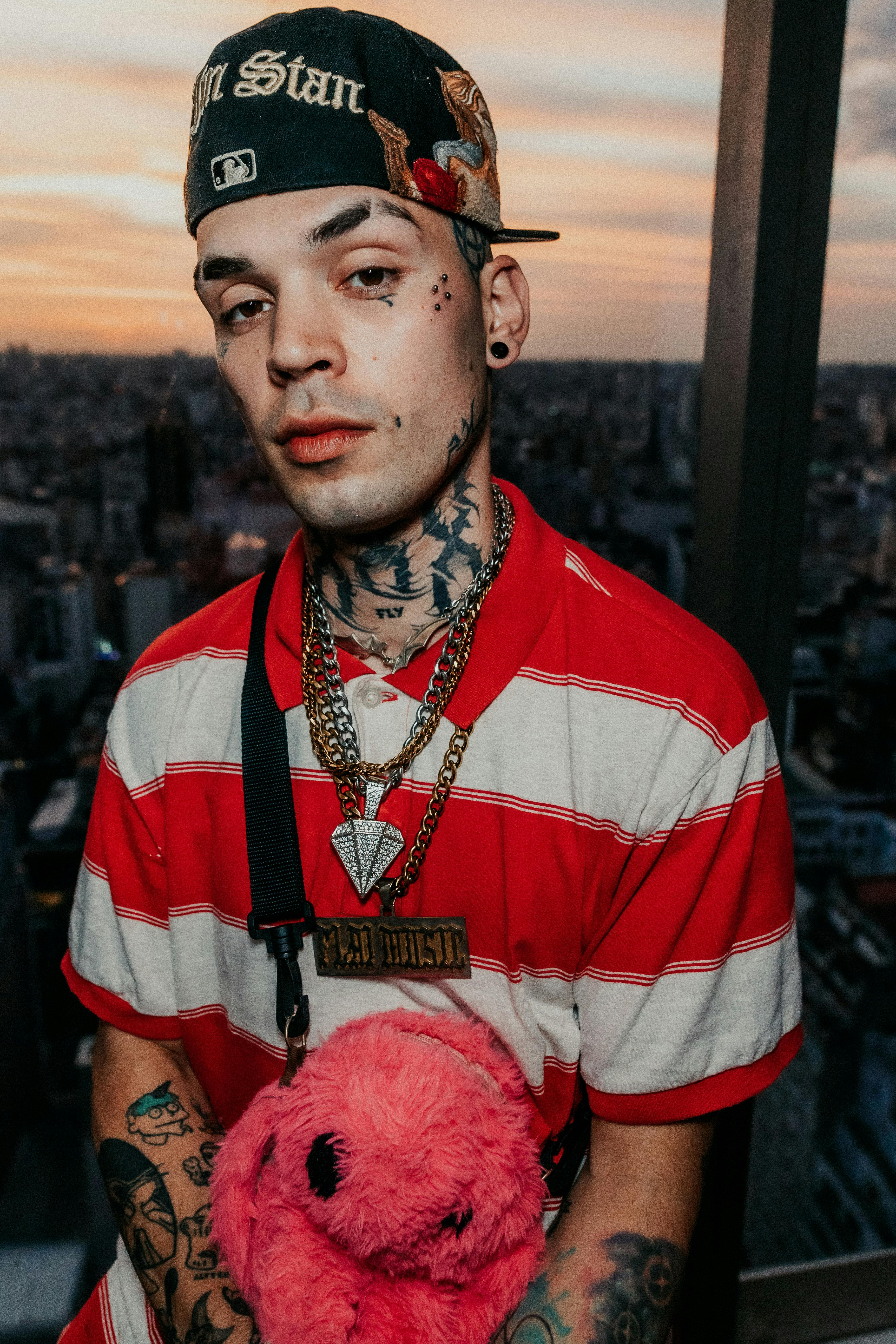 Stylish young adult with tattoos poses at sunset overlooking Buenos Aires skyline.