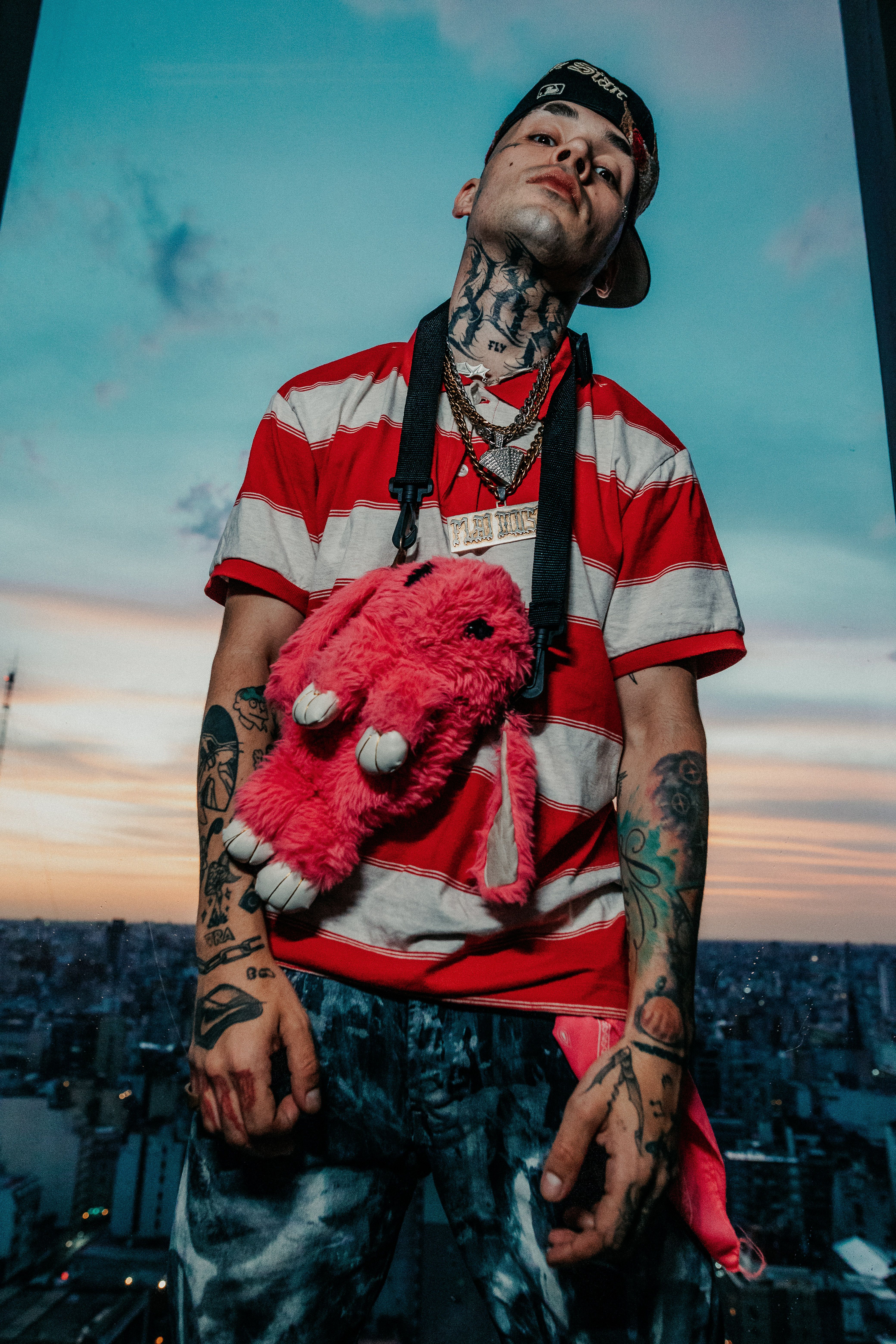 Dynamic urban portrait of a tattooed individual with street style against a vibrant Buenos Aires sunset.