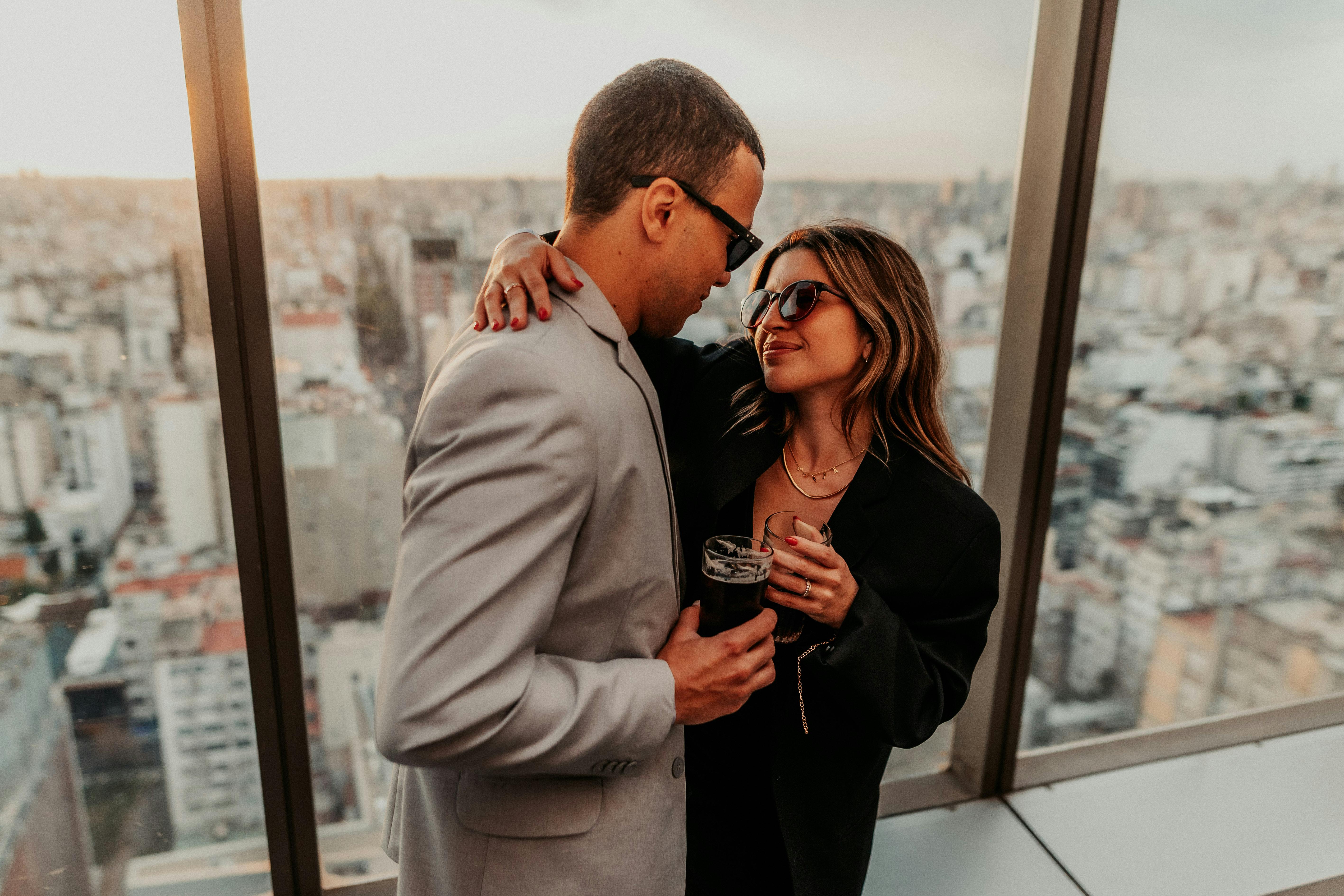 A couple enjoying a romantic moment overlooking Buenos Aires at sunset, from a high vantage point.