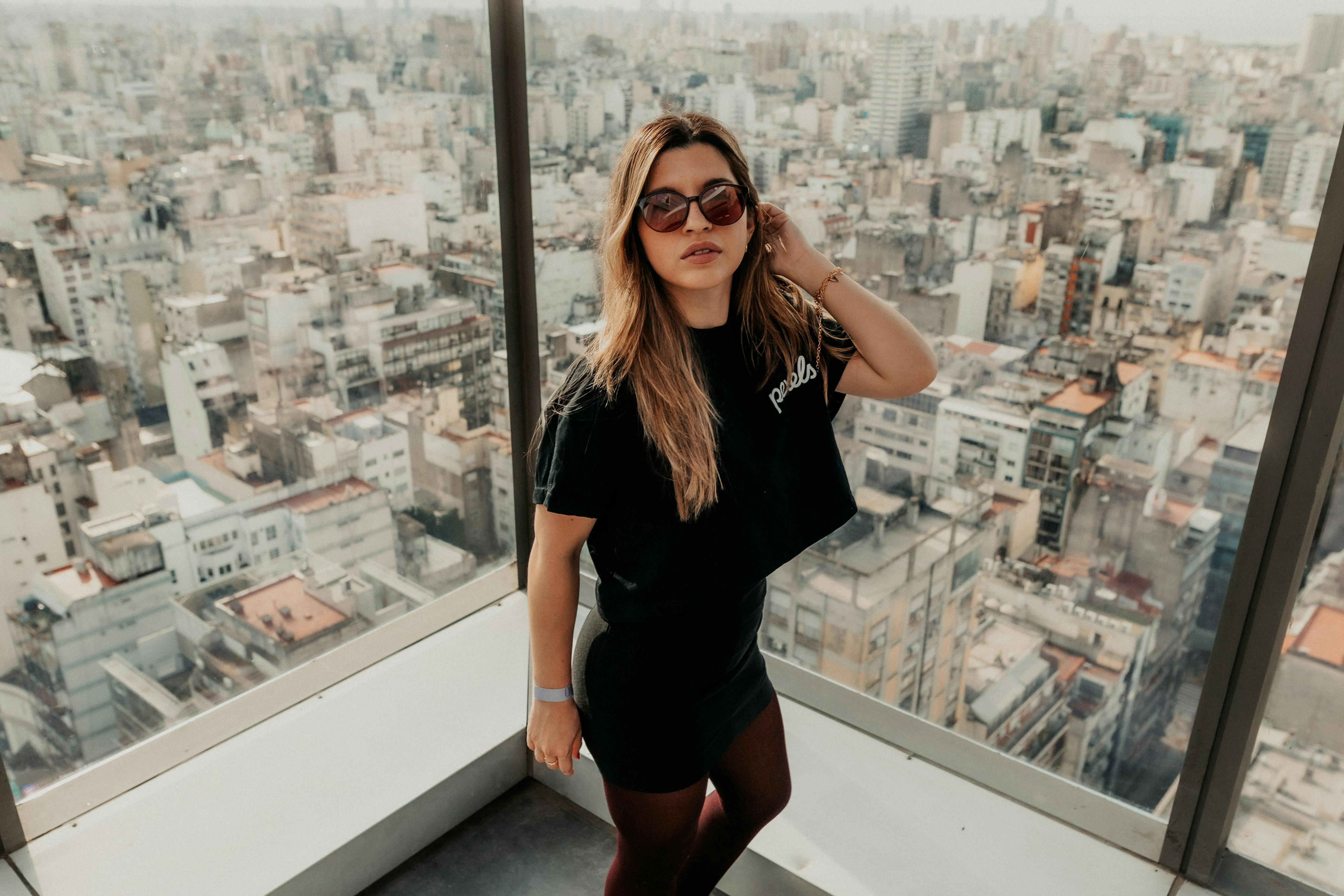 Free Stylish young woman in sunglasses posing against the stunning Buenos Aires skyline. Stock Photo