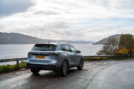 A Volkswagen SUV parked near a scenic lake with a mountainous backdrop.