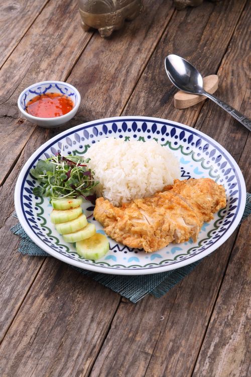 Free Delicious crispy fried chicken served with rice, cucumber, and salad. Stock Photo