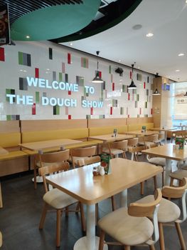 Bright and inviting restaurant interior with 'Welcome to the Dough Show' sign.