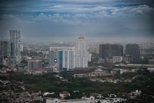 Stunning aerial view of Jakarta's skyline with modern skyscrapers and cloudy sky.