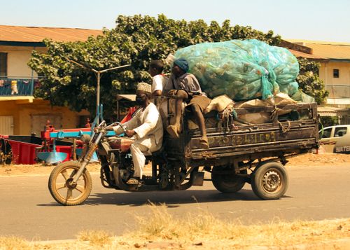 Free A motorbike in motion carrying multiple passengers and goods on an urban road. Stock Photo