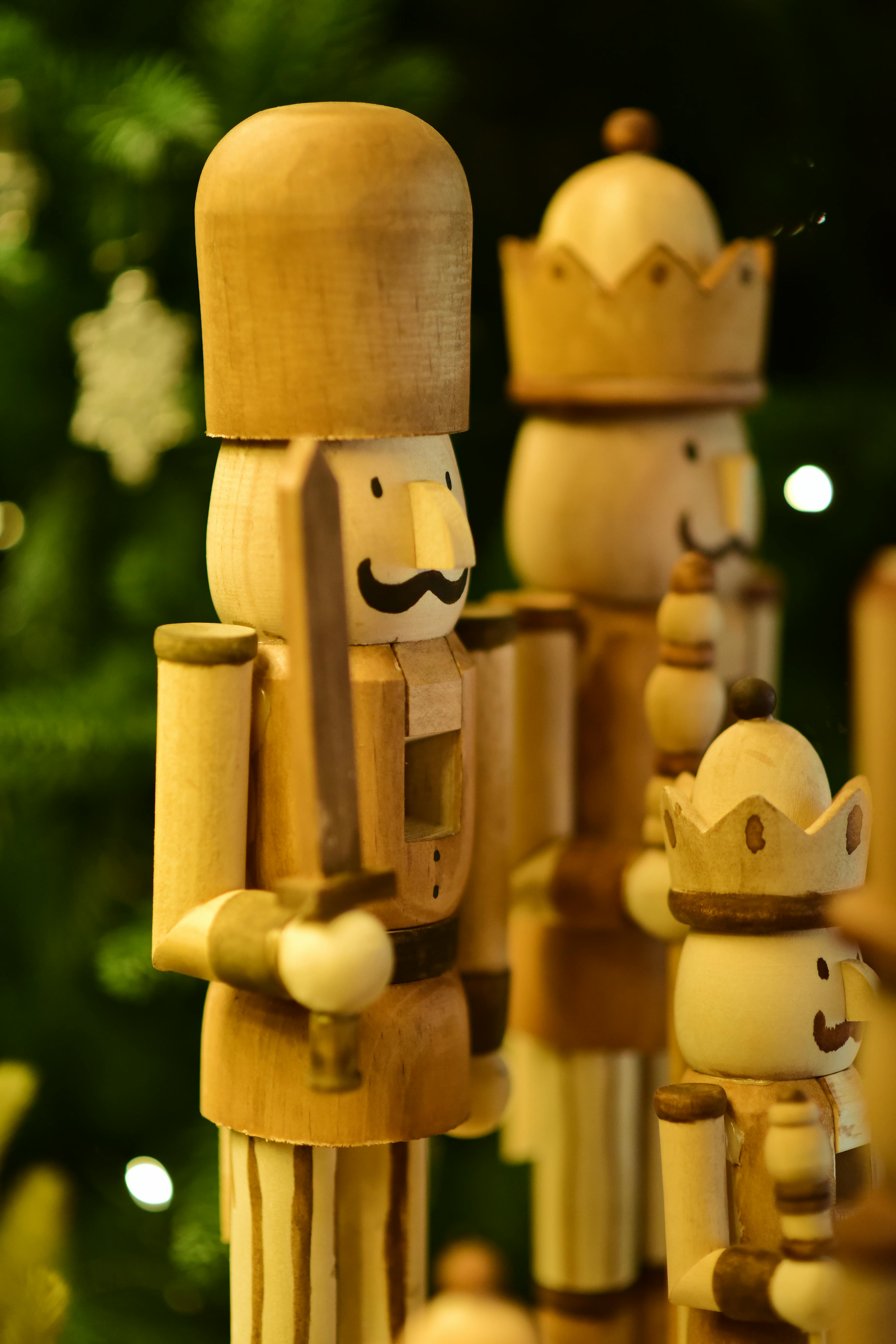 Charming wooden nutcracker figures in front of a festive tree with soft lighting.