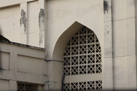 Close-up of a weathered architectural facade with geometric patterns and peeling paint.