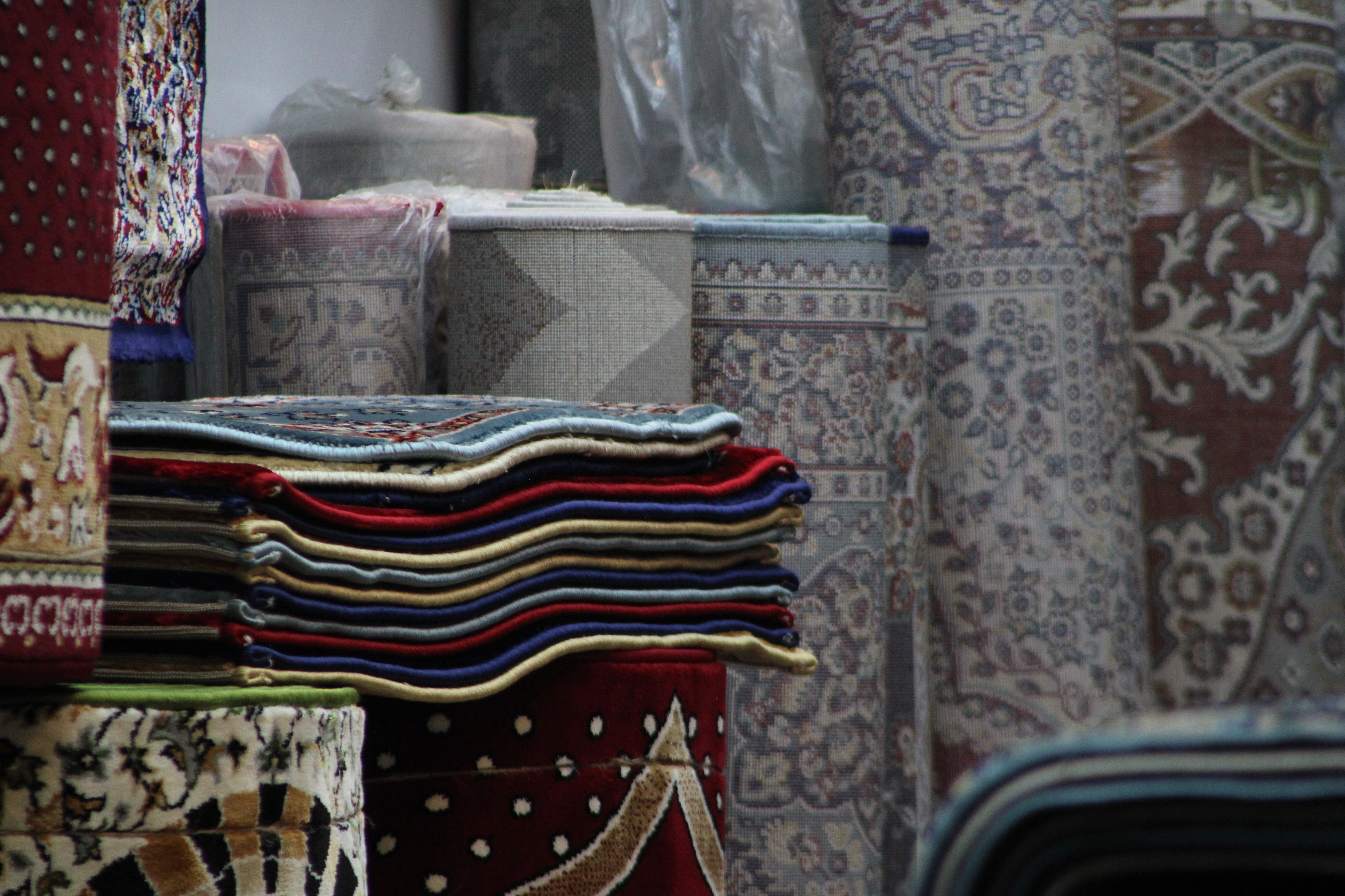 Colorful Stacked Rugs in a Traditional Bazaar · Free Stock Photo