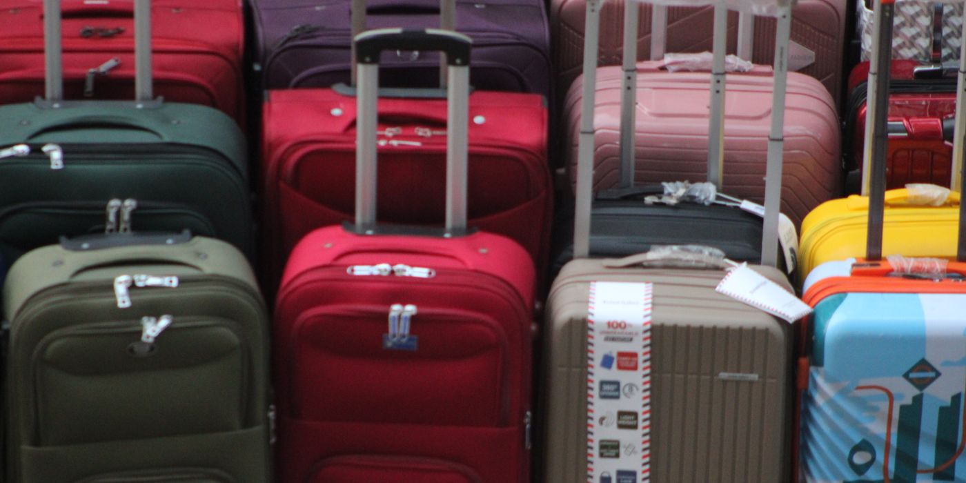 A vibrant collection of various suitcases stacked in preparation for travel.