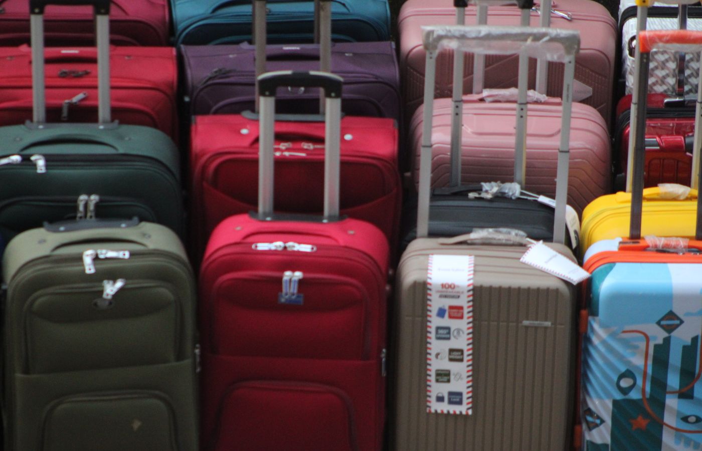 A vibrant collection of various suitcases stacked in preparation for travel.