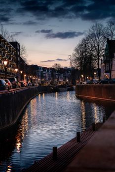 Beautiful canal in Amsterdam during twilight with reflections on water