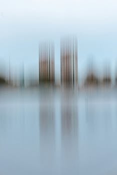 Artistic blur of skyscrapers reflecting on water, creating an abstract cityscape.