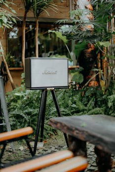 A vintage-style speaker amidst lush indoor greenery creates a relaxing ambiance.