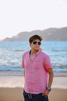 Casual man in sunglasses on a sunny beach, relaxed summer vibe.