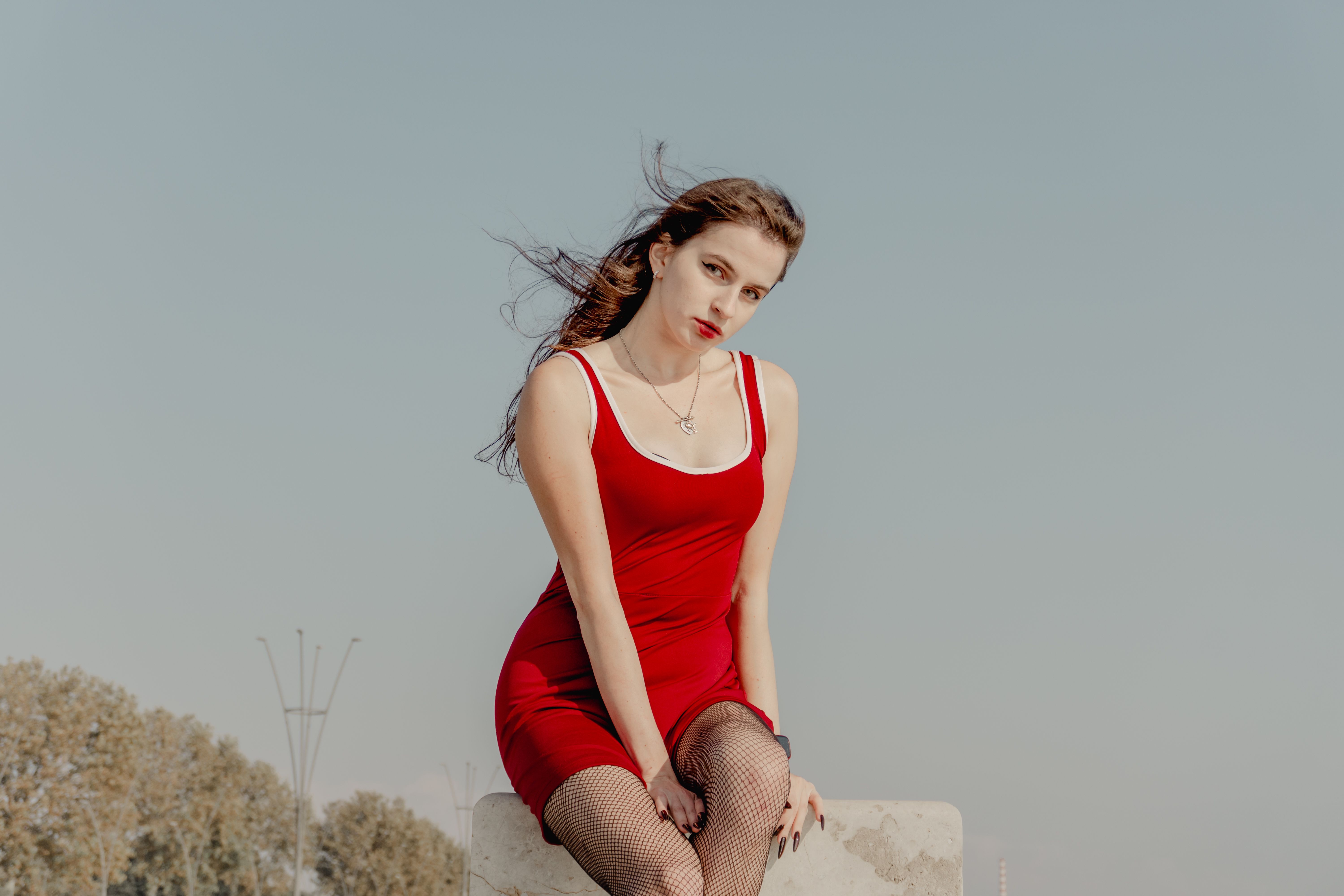 Elegant Woman in Red Dress Posing Outdoors · Free Stock Photo
