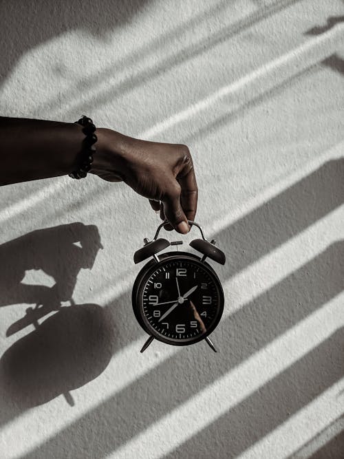 Free Person Holding a Alarm Clock Stock Photo
