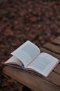 Open Book on Wooden Table in Autumn Setting