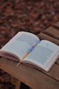 Open Book on Wooden Bench with Feather Bookmark