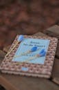 Book on Wooden Bench with Blue Flowers