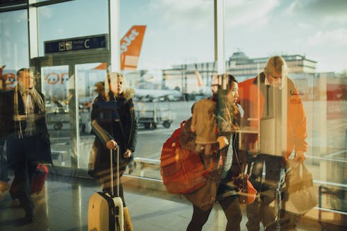 People Walking on Path Through Glass Walls at Daytime