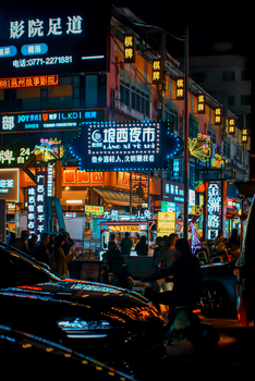 Bustling Asian street scene with neon lights and lively nightlife.