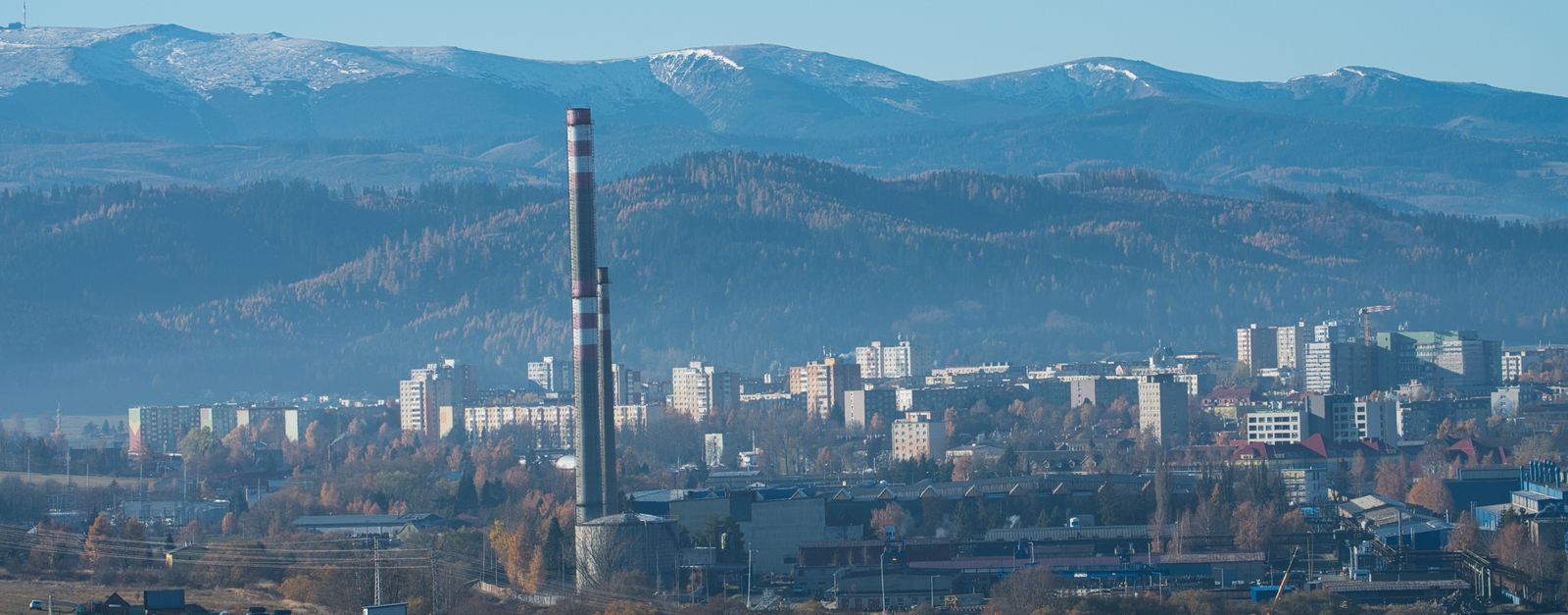Captivating view of Poprad cityscape with High Tatra mountains in the background on a clear day.