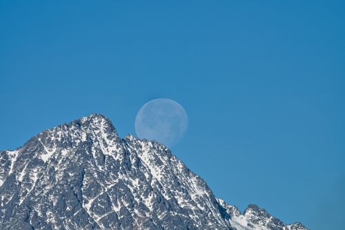 Free Stunning view of snow-capped High Tatras with the moon in the clear sky. Stock Photo