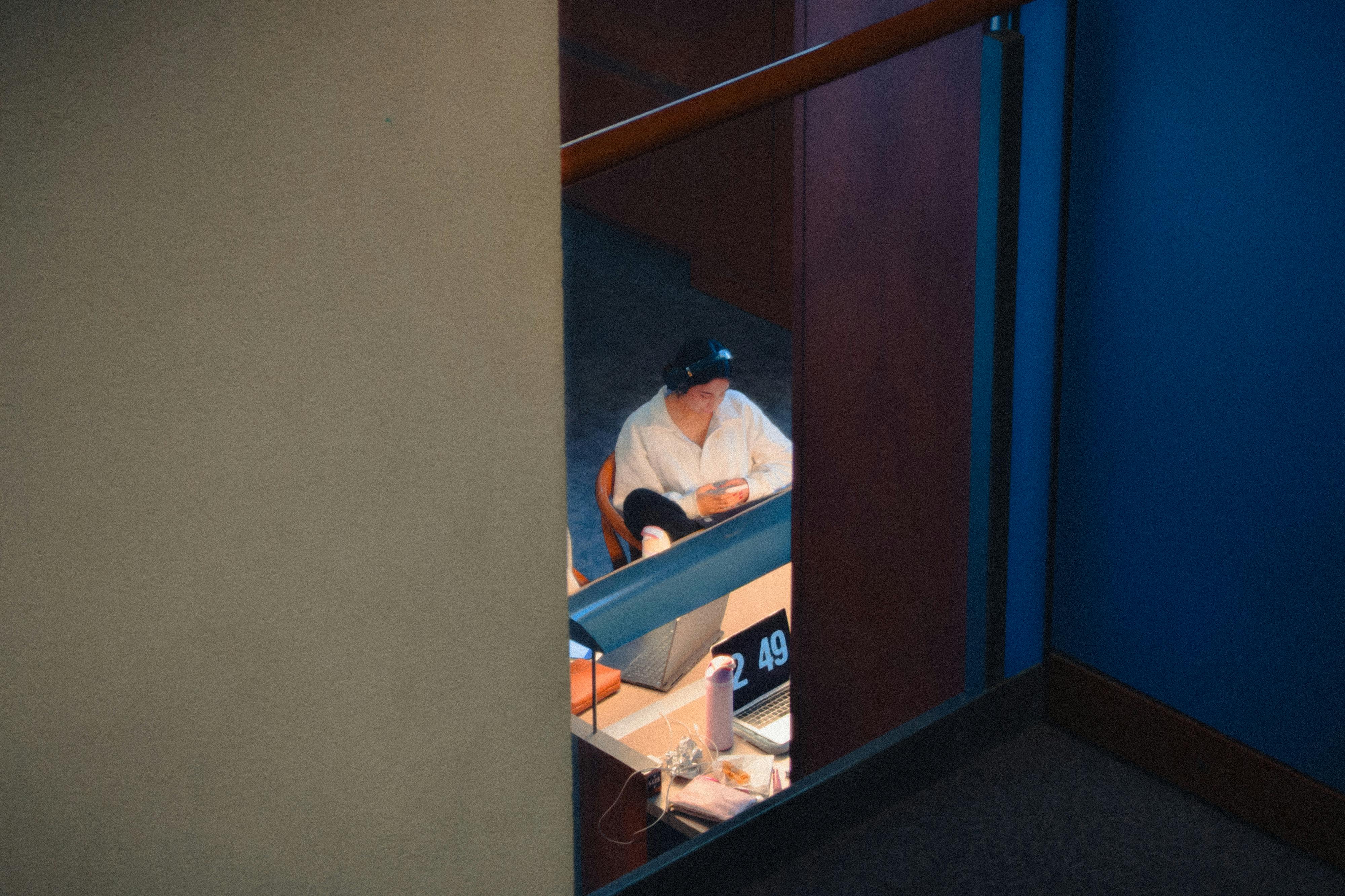 Gratis Persona che utilizza un computer portatile in un ambiente interno a Kingston, Ontario, vista attraverso una parete di vetro. Foto a disposizione