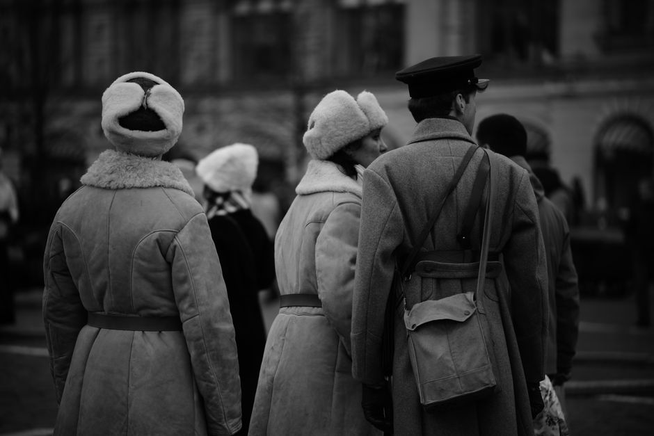 Group of people in vintage winter clothing outdoors, black and white photo.