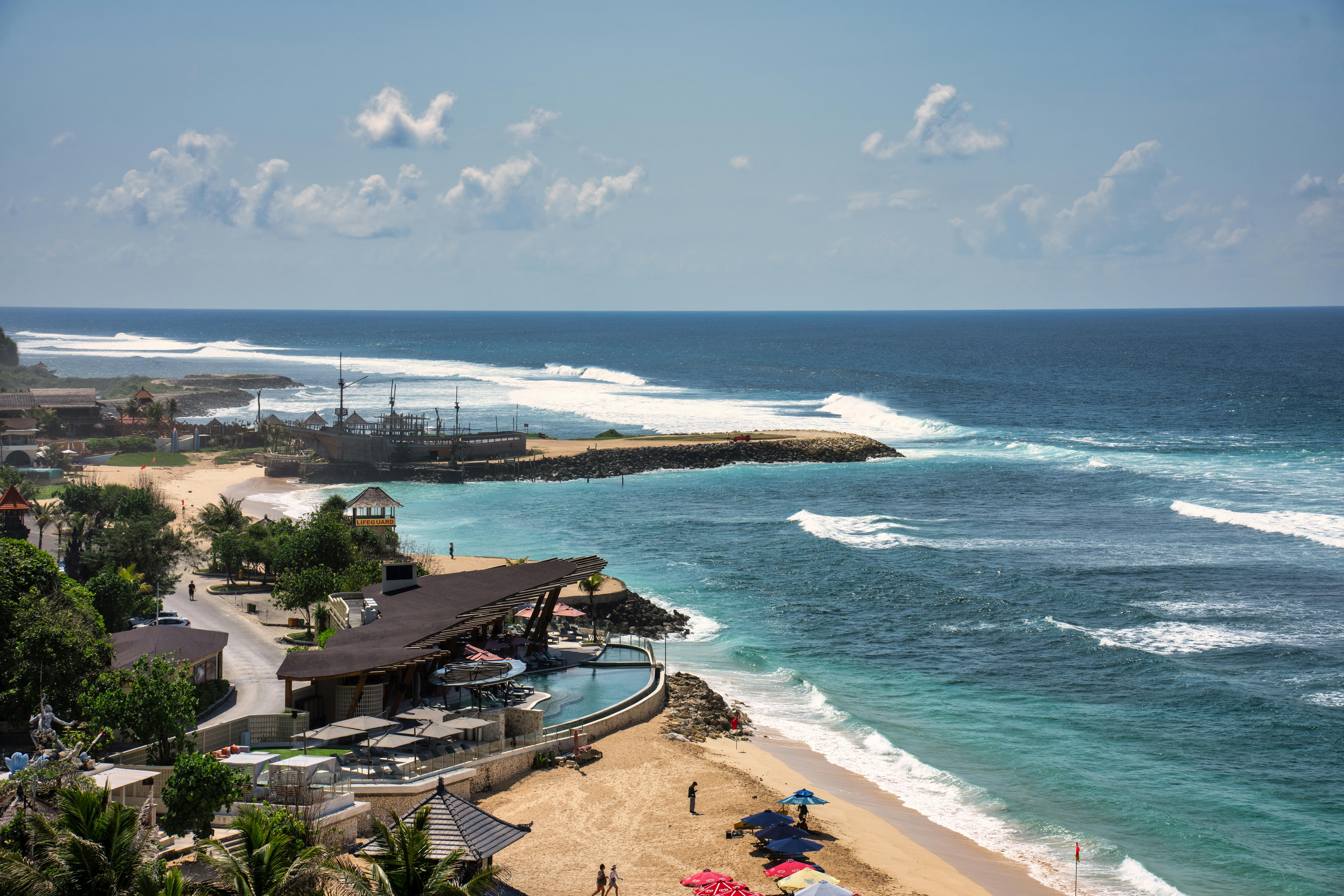 Explore the stunning coastline of Bali with pristine beaches and azure waters under a bright summer sky.