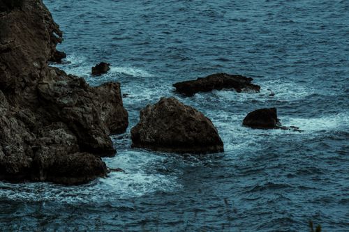 Free Dramatic rocky coastline with waves on the Mediterranean Sea during twilight. Stock Photo
