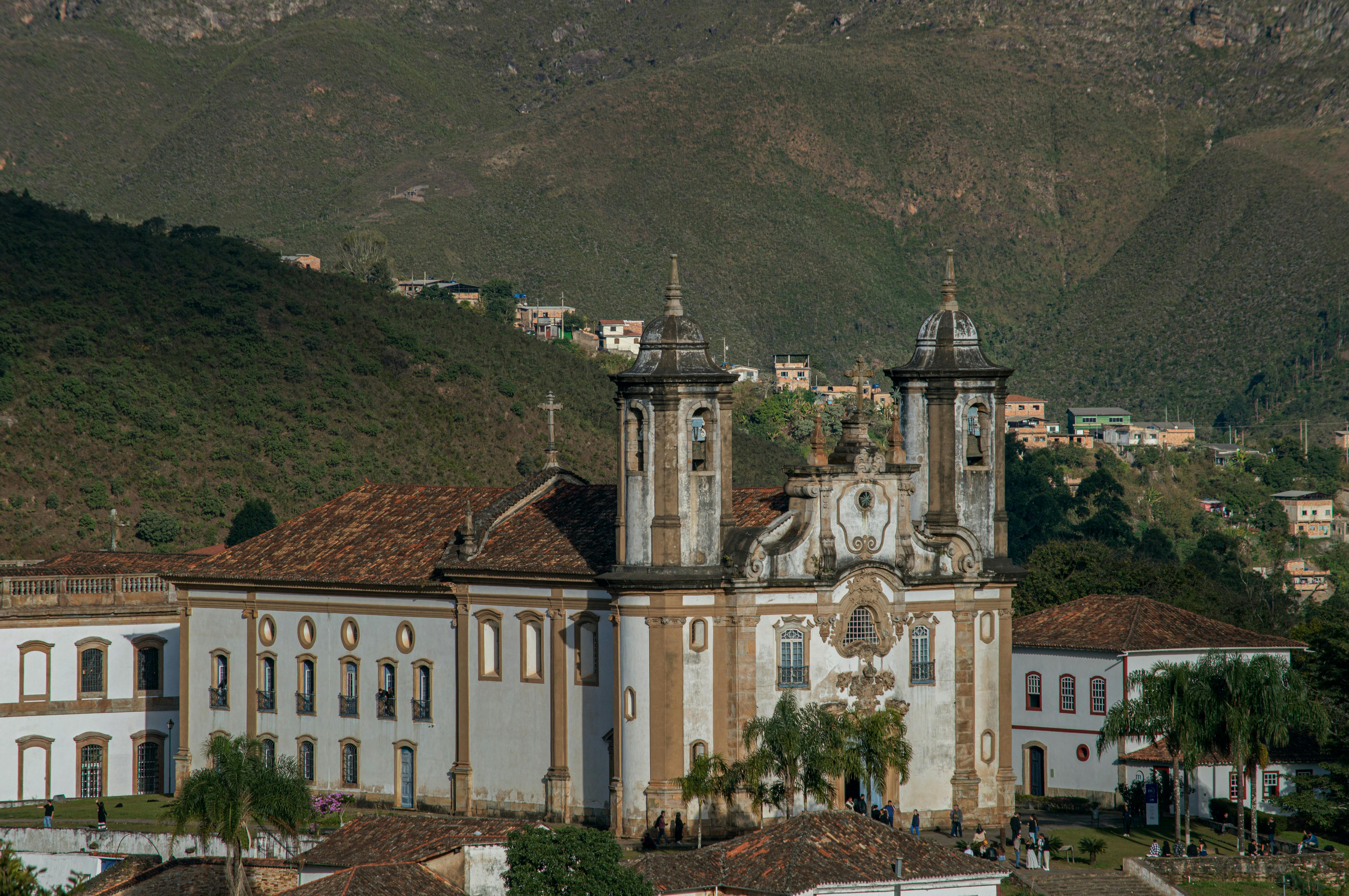 Baroque church surrounded by hills in historic Brazilian city, showcasing colonial architecture.