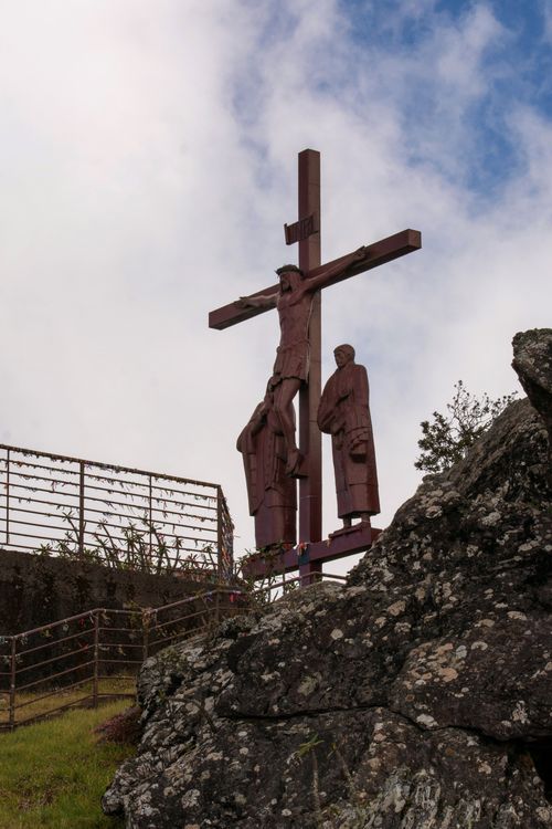 Free Monument of crucifixion depicting religious figures in a historic setting, with cloudy sky backdrop. Stock Photo