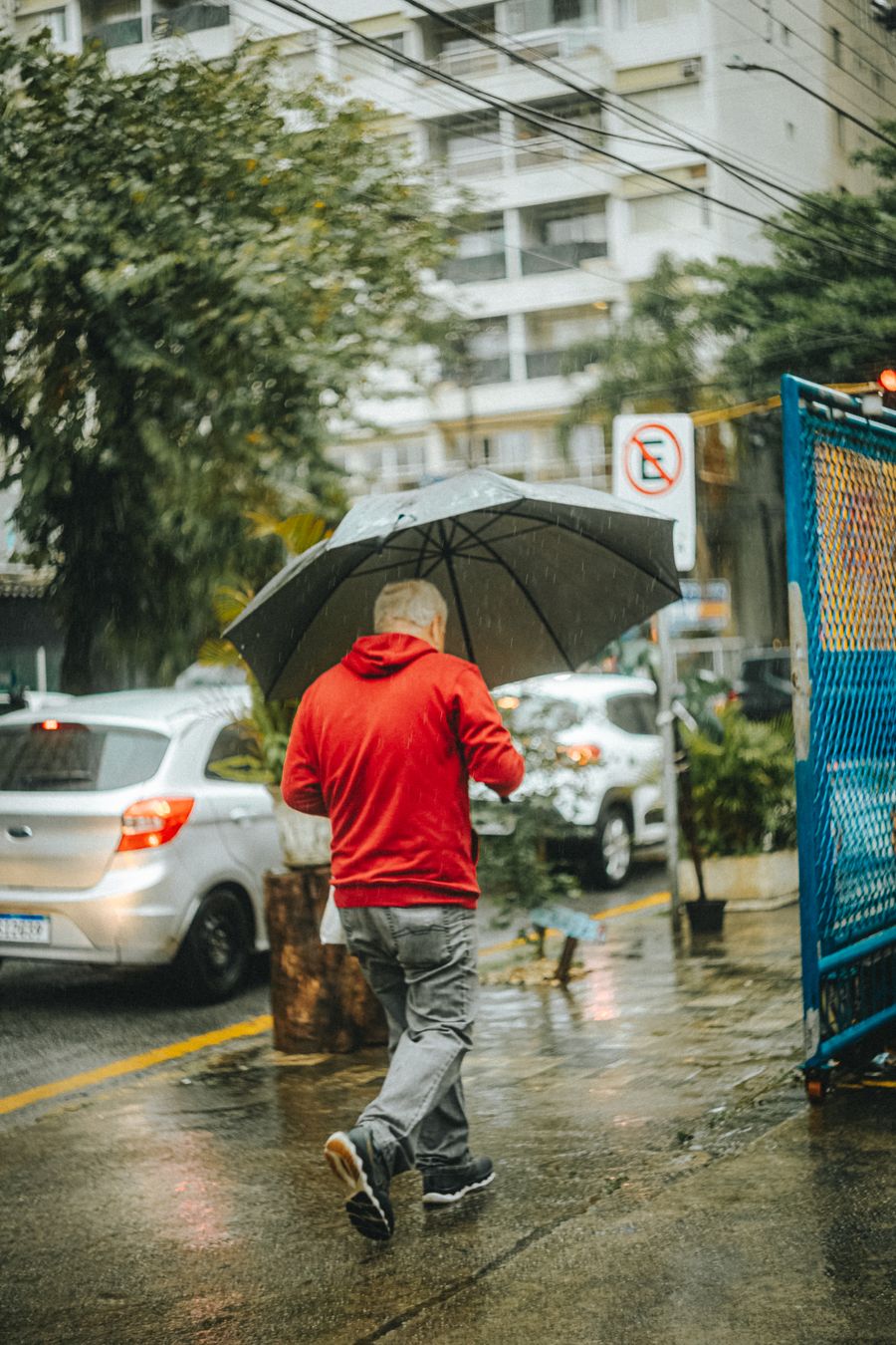 Persona con chaqueta caminando bajo la lluvia en la ciudad