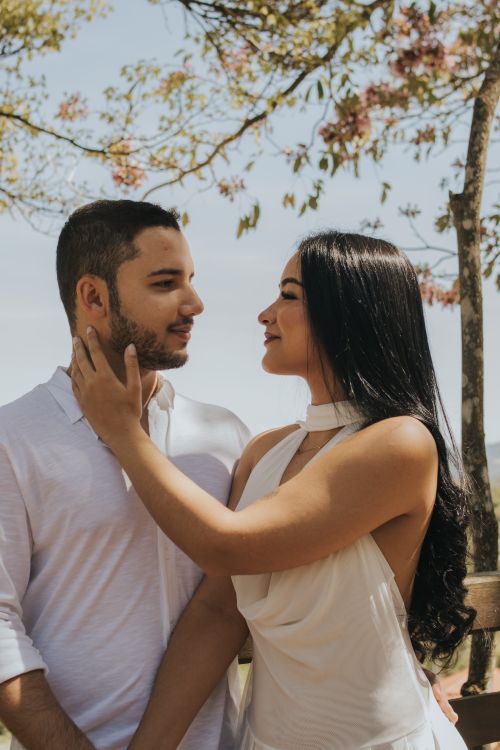 Free A couple in love shares an intimate moment under blooming trees during spring. Stock Photo