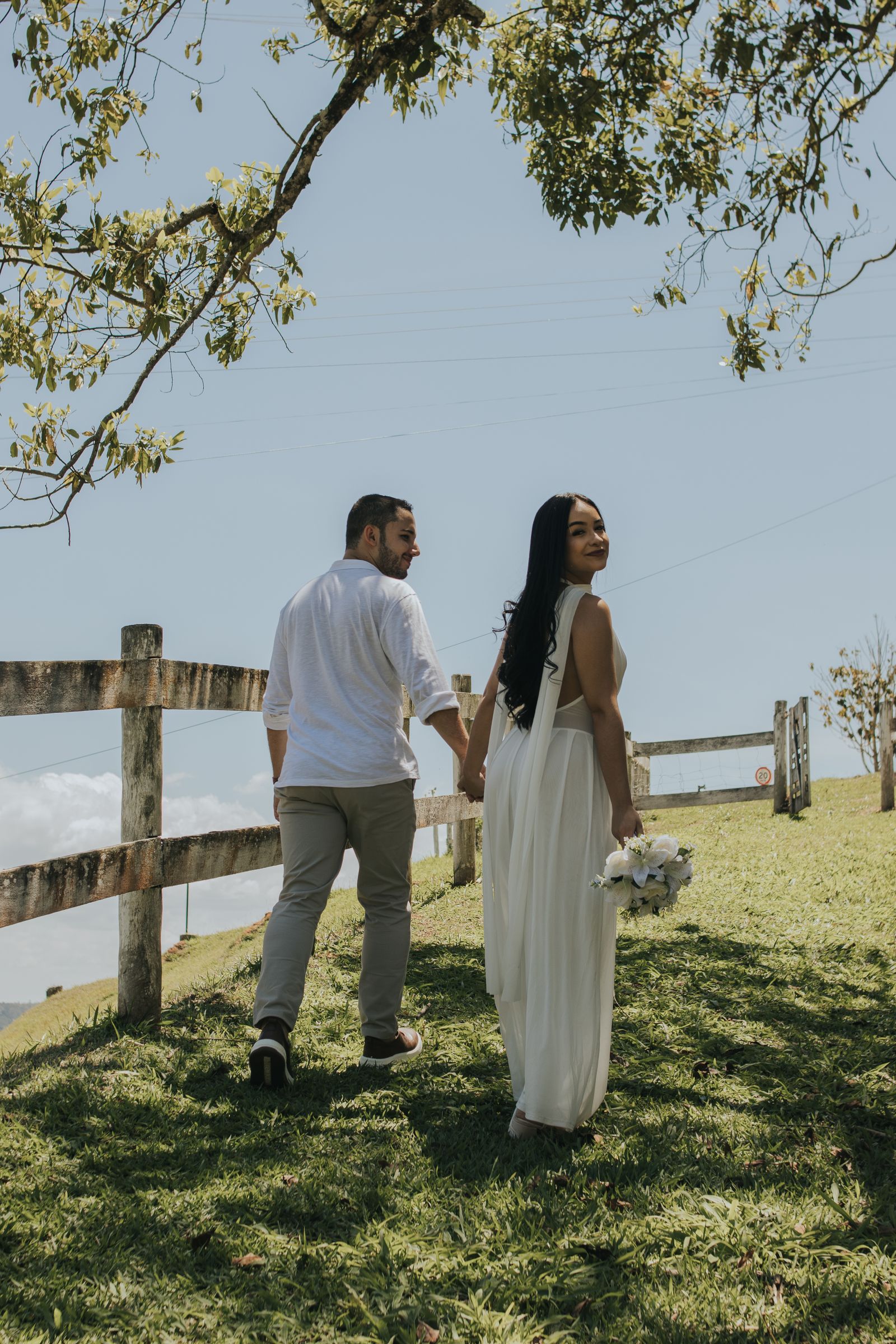 Two people holding hands during an outdoor wedding