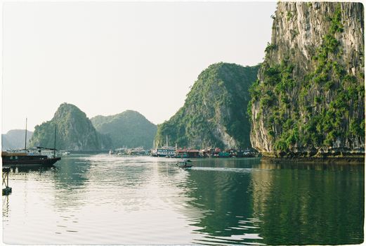 Picturesque Halong Bay with traditional boats against limestone karsts in Vietnam.