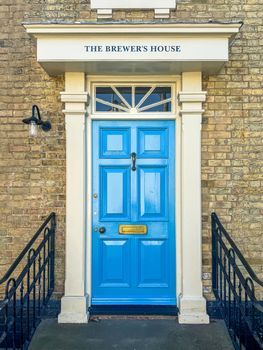 Stylish entrance with a vibrant blue door at The Brewer's House in Southwold, England.