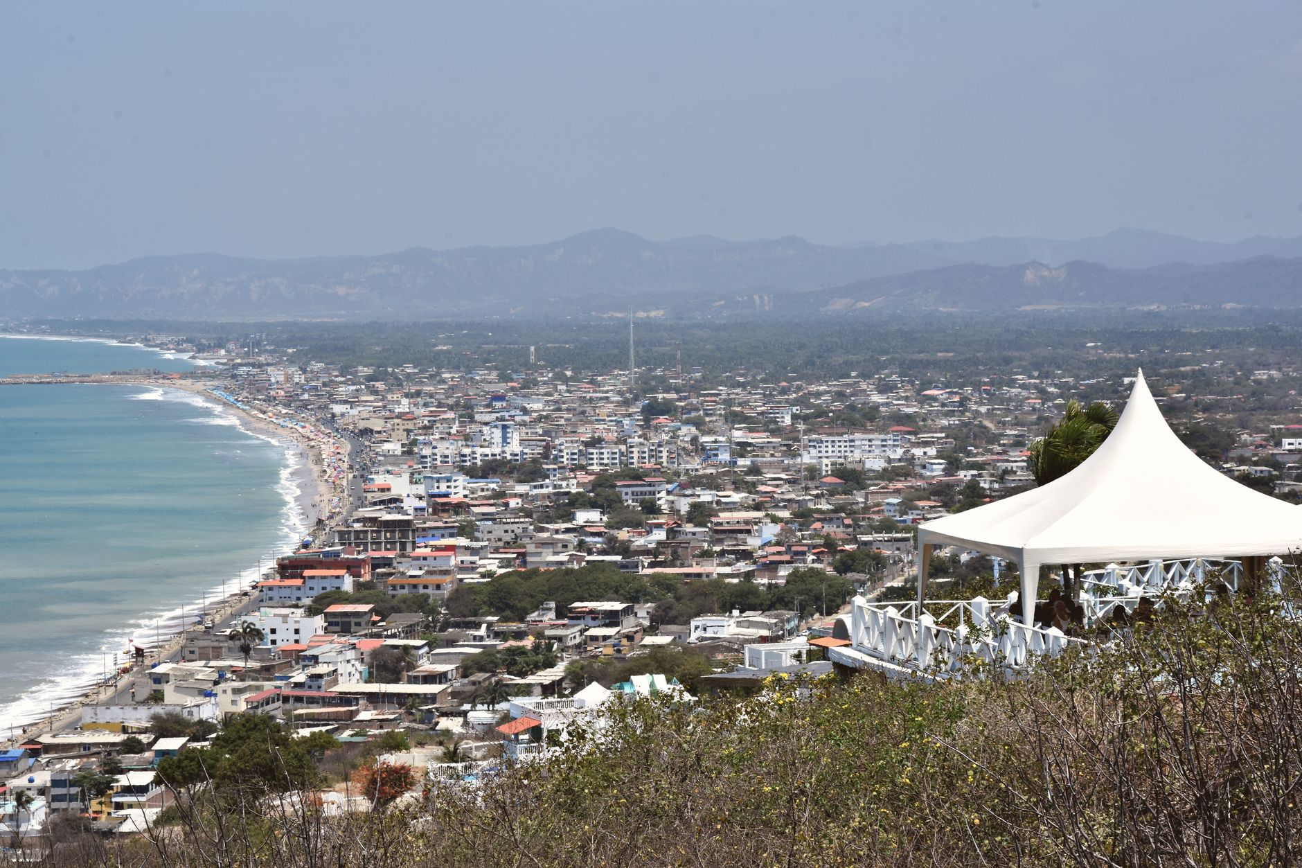 A panoramic view of the bustling coastal city of Manta, Ecuador, from a hilltop vantage point.