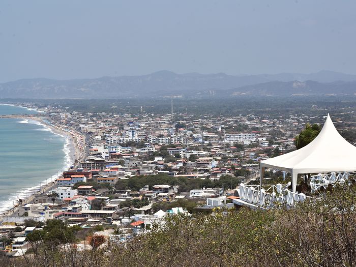 A panoramic view of the bustling coastal city of Manta, Ecuador, from a hilltop vantage point.