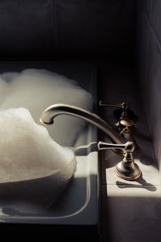 Luxurious bath scene with elegant faucet and foam, capturing indoor tranquility.