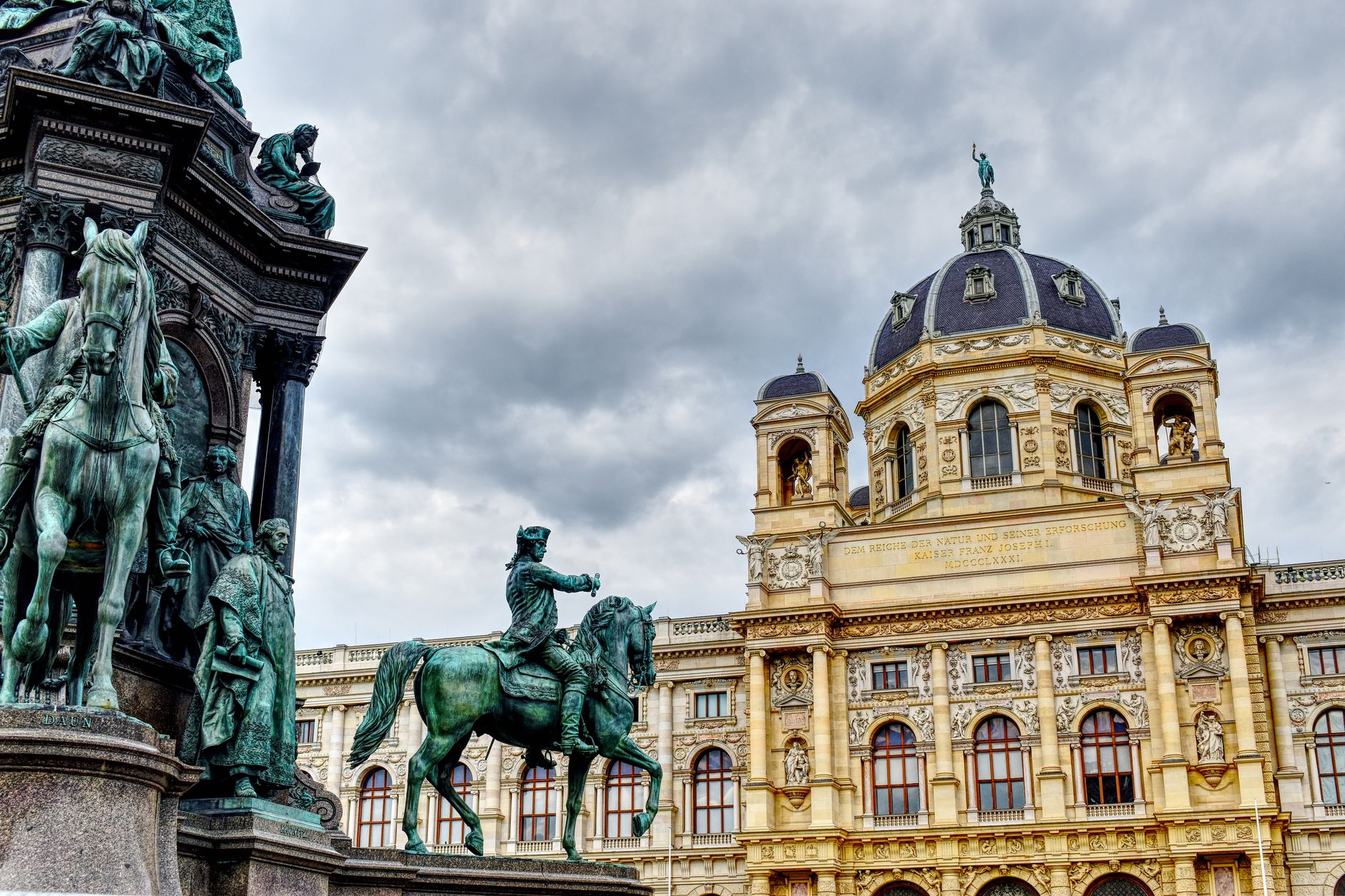 Magnificent view of Vienna's Kunsthistorisches Museum and the Maria Theresa monument under a cloudy sky.